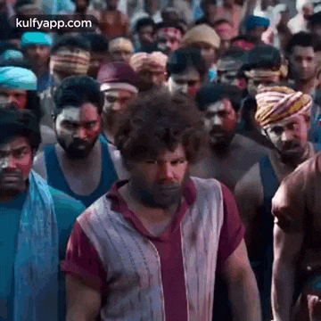 a group of men are standing in a crowd .