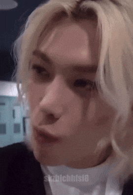 a close up of a person 's face with blonde hair making a face .