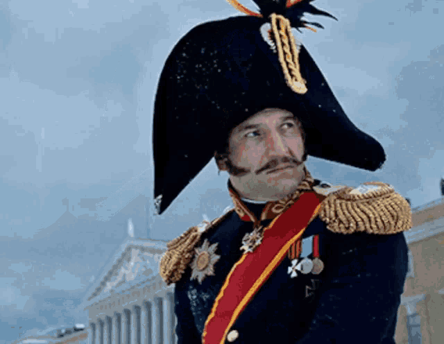 a man in a military uniform is wearing a large hat with a feather on it