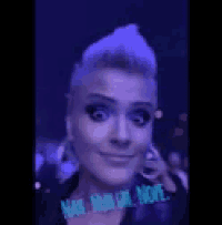 a woman with purple hair is making a funny face and has the words nope written on her face .