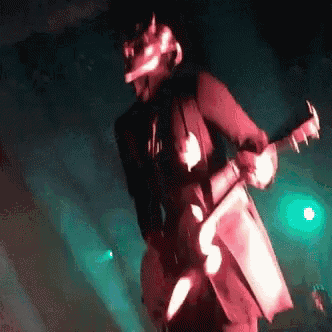 a man is playing a guitar in a dark room