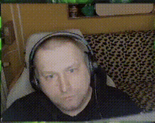 a man wearing headphones sits on a couch