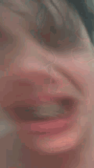 a young man with braces on his teeth is crying with his eyes closed