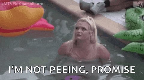 a woman is sitting in a swimming pool with an inflatable crocodile and a pink duck .
