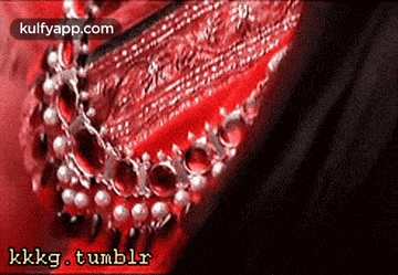 a close up of a necklace on a red background with the words kkkg tumblr on the bottom