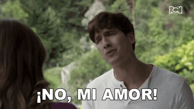a man in a white shirt is talking to a woman and says no mi amor