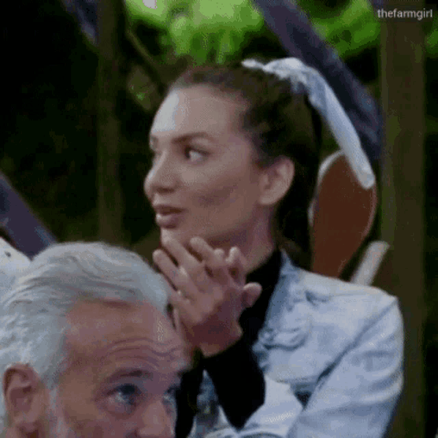a woman is sitting next to a man with gray hair .