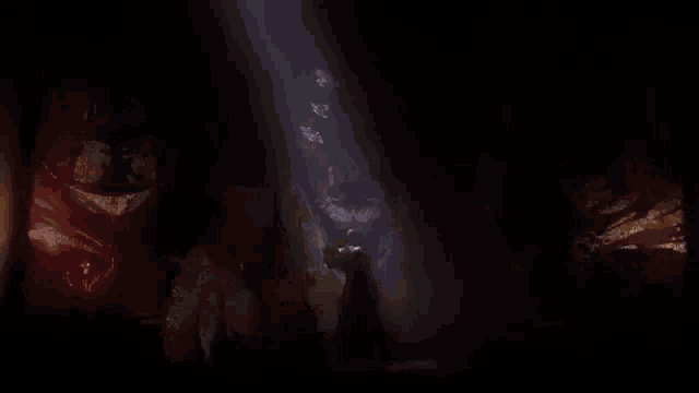 a bald man with elf ears is standing in a dark room in a video game .