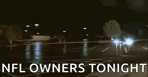 a car is driving down a parking lot at night with the words nfl owners tonight on the bottom