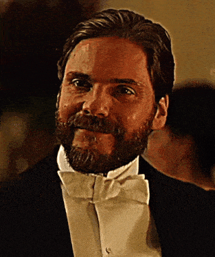 a man with a beard and bow tie is smiling