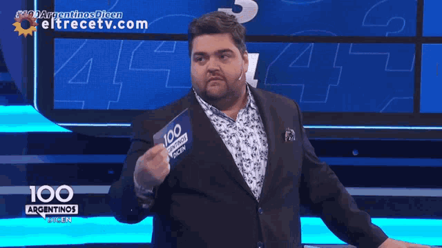 a man in a suit is standing in front of a screen that says con esa seguridad