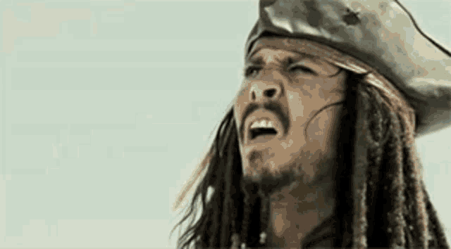 a close up of a man wearing a pirate hat and dreadlocks .