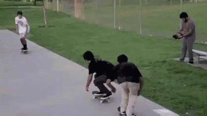 a group of people are riding skateboards down a sidewalk .
