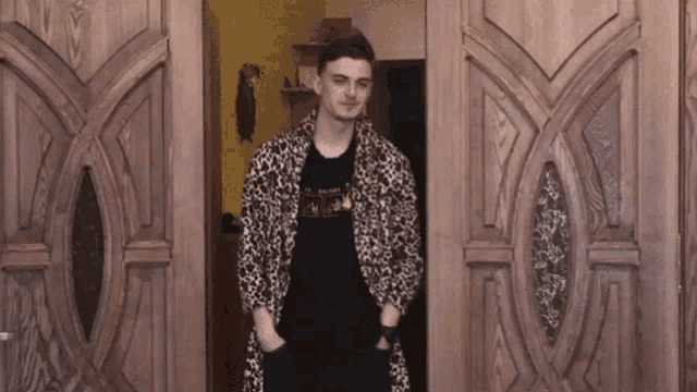 a man in a leopard print robe is standing in a doorway