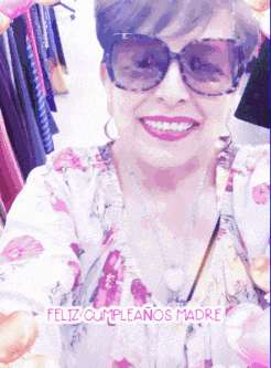 a woman wearing sunglasses and a floral shirt is smiling with the words feliz cumpleanos madre above her