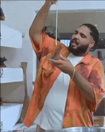 a bearded man in an orange shirt is holding a spoon in his hand