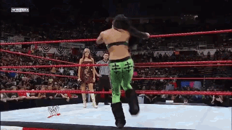 a woman in a wrestling ring with a referee and a sign that says wwf hd