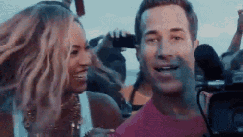 a man and a woman are standing next to each other in a crowd .