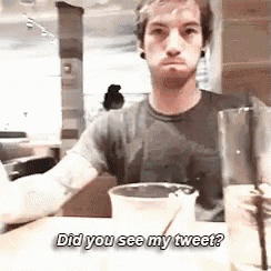 a man is sitting at a table with a cup of coffee and the words did you see my tweet on the table .