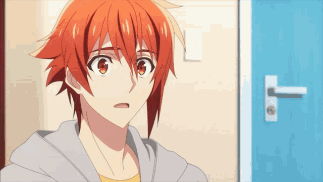 a boy with orange hair is standing in front of a door