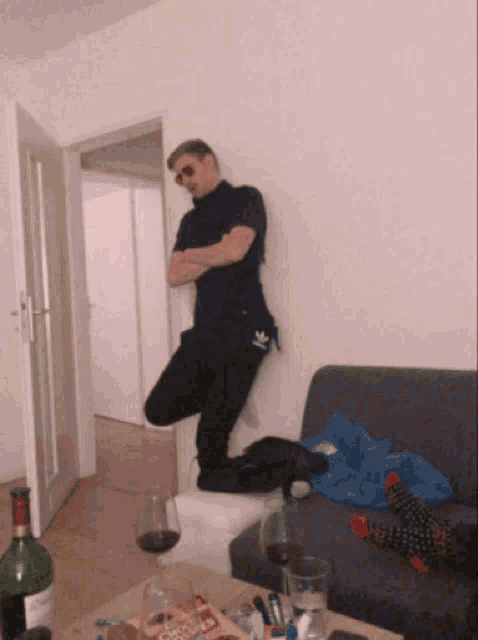 a man standing on one leg in a living room with a bottle of coca cola on the table