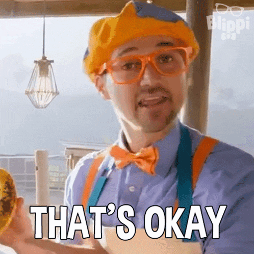 a man in a clown costume is holding a sunflower and says that 's okay .