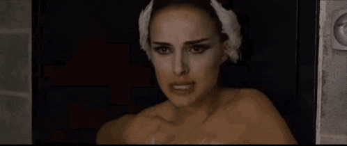 a woman in a black dress is dancing in a dressing room .
