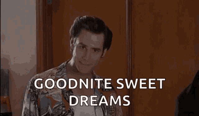 a man in a colorful shirt is standing in front of a door and says `` goodnite sweet dreams '' .