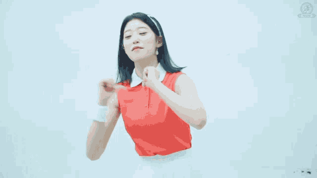 a woman in a red top and white skirt is dancing in a room with a clock on the wall .