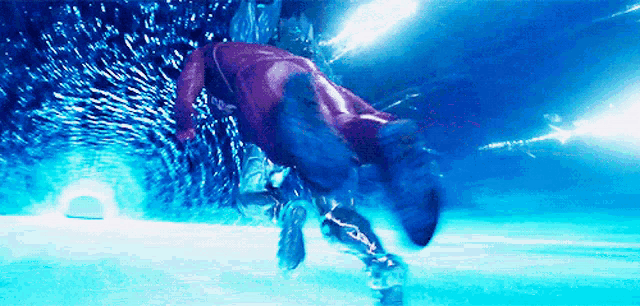 a person in a red suit is jumping into a pool of water