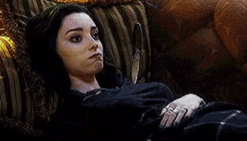 a woman is laying on a couch with a green light coming out of her face .