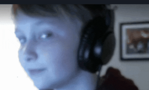 a boy wearing headphones is looking at the camera
