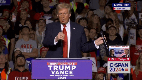 a man stands at a podium with a sign that says trump will fix it