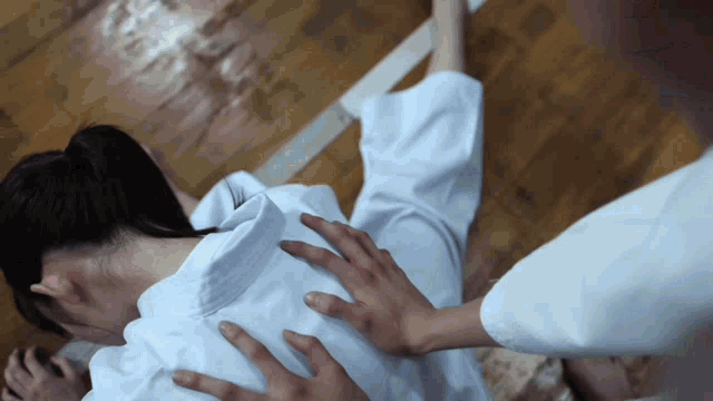 a woman in a white robe is getting a massage from a man in a white robe