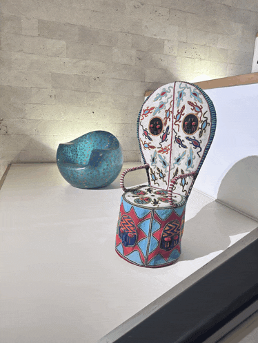 a chair with a face on it sits next to a blue bowl