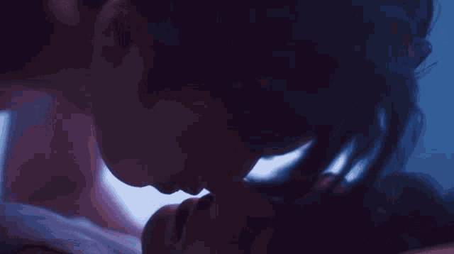 a man and a woman are kissing in the dark