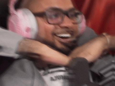 a man wearing headphones and glasses is hugging another person .