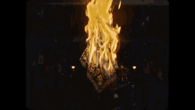 a bandana is burning in the dark with flames coming out of it .