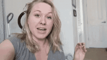 a woman is standing in a room with a vacuum cleaner in her hand .