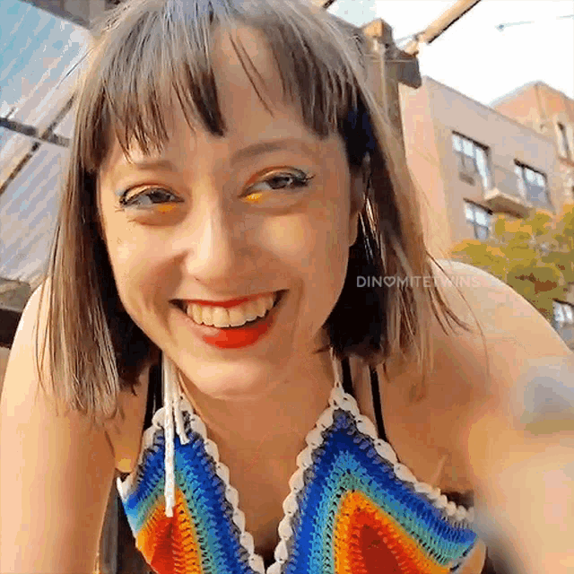 a woman wearing a colorful crocheted top smiles for the camera with the words " dinomite twins " below her