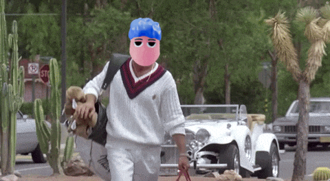 a man wearing a pink mask is walking down a street in front of a stop sign
