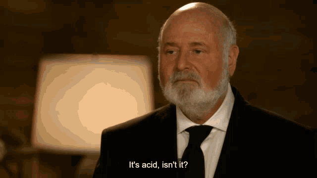 a man in a suit and tie says it 's acid , isn 't it ?