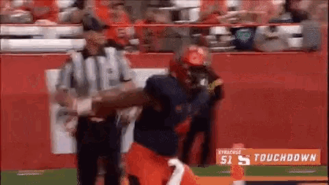 a football player is being tackled by a referee on the field