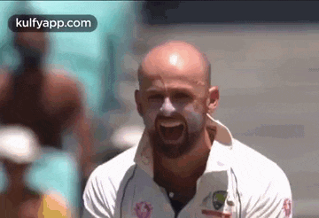 a bald man with a beard is screaming with his mouth wide open .