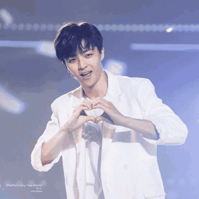 a young man making a heart shape with his hands with the words mama 's fairy tale world below him