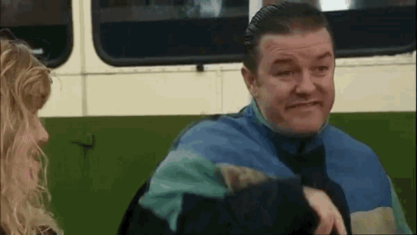 a man in a blue jacket is talking to a woman in a green bus
