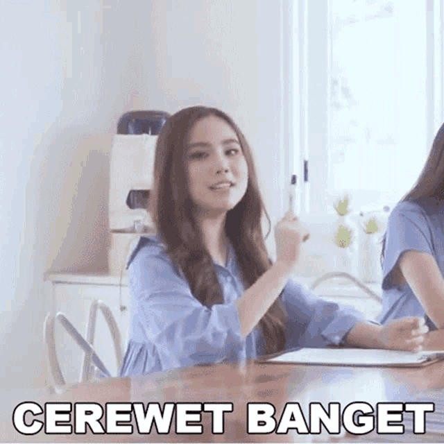 a woman sitting at a table with the words cerewet banget written on the bottom