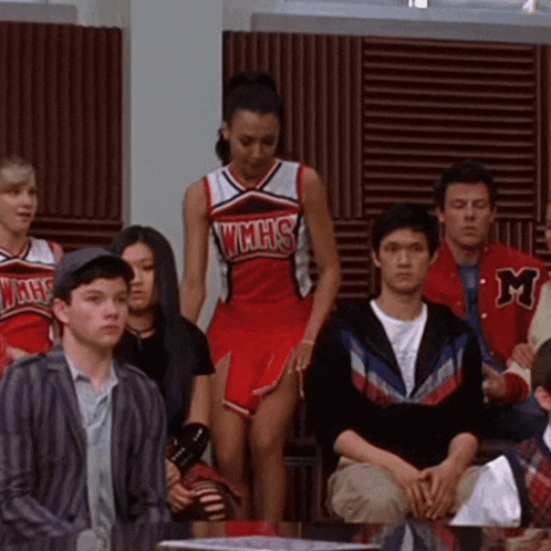 a cheerleader in a wmhs uniform stands in a crowd