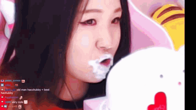 a girl with a stuffed animal in her mouth has a lot of white powder on her face