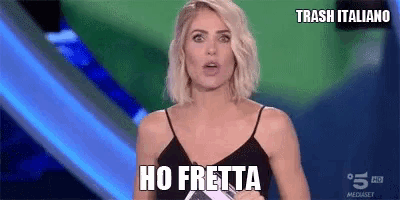 a woman is standing on a stage with a sign that says ho fretta .